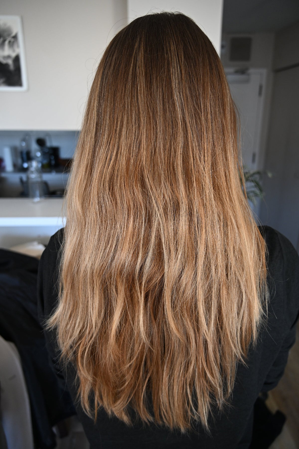Person with long, wavy hair in a kitchen setting